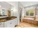 Elegant bathroom boasts a soaking tub, glass shower, granite vanity, and ample natural light for a spa-like experience at 11201 Jonas Ridge Ln, Raleigh, NC 27613