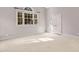 Sunlit carpeted bedroom with light gray walls and bright, natural light from a large window at 11201 Jonas Ridge Ln, Raleigh, NC 27613