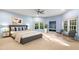 Bedroom featuring a ceiling fan, large windows, and neutral carpet perfect for relaxation at 11201 Jonas Ridge Ln, Raleigh, NC 27613