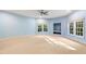 Room featuring a ceiling fan, multiple windows, and neutral carpet perfect for relaxation at 11201 Jonas Ridge Ln, Raleigh, NC 27613