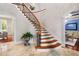 Grand curved staircase with ornate iron railing and wood steps at 11201 Jonas Ridge Ln, Raleigh, NC 27613