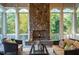 Sunroom features a stone fireplace and comfortable seating at 11201 Jonas Ridge Ln, Raleigh, NC 27613