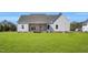Rear view of the home showcasing a covered patio and expansive yard in a serene setting at 1178 Sheriff Johnson Rd, Lillington, NC 27546