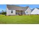 Home's back exterior features a covered patio, and a well-maintained lawn, ideal for outdoor activities at 1178 Sheriff Johnson Rd, Lillington, NC 27546