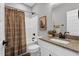 Bathroom featuring a shower-tub combo with brown shower curtain, along with modern fixtures and granite countertop at 1178 Sheriff Johnson Rd, Lillington, NC 27546