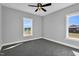 Cozy bedroom with a ceiling fan, carpet flooring, and two windows providing natural light at 1178 Sheriff Johnson Rd, Lillington, NC 27546