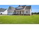 Lovely home exterior with a two-car garage, covered porch, and manicured lawn on a bright day at 1178 Sheriff Johnson Rd, Lillington, NC 27546