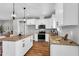 Modern kitchen with island, granite countertops, and stainless steel appliances provides ample space for cooking at 1178 Sheriff Johnson Rd, Lillington, NC 27546