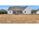 Rear exterior view of a home with vinyl siding, covered porch, and ample backyard space at 1178 Sheriff Johnson Rd, Lillington, NC 27546