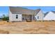 Exterior rear of a home with a covered porch showcasing modern design and spacious backyard at 1178 Sheriff Johnson Rd, Lillington, NC 27546