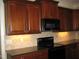Modern kitchen featuring dark wood cabinets, granite countertops, and a built-in microwave at 166 Easy Wind Ln, Garner, NC 27529