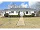 White Ranch home with gray roof, landscaping, and walkway at 1805 Brown Ave, Burlington, NC 27215