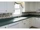 Bright kitchen with white cabinets, green countertops, and floral wallpaper at 1805 Brown Ave, Burlington, NC 27215
