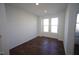 Bright bedroom with dark hardwood floors and two windows at 1928 Robin Hill Ln, Raleigh, NC 27610