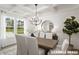 Bright dining room with coffered ceilings, modern chandelier, and large windows showcasing outdoor views at 23 Frost Meadow Way, Lillington, NC 27546