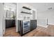 Stylish bar area features a sleek wine fridge, black cabinets and floating shelves in an open floor plan at 313 E Fourth St, Wendell, NC 27591