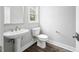 Half bathroom with a pedestal sink, toilet, and modern finishes at 313 E Fourth St, Wendell, NC 27591