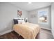 A modern bedroom features hardwood floors, a white bed, and a large window with natural light at 313 E Fourth St, Wendell, NC 27591