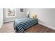 Bedroom with hardwood floors, a bed with striped sheets, neutral walls, and a window at 313 E Fourth St, Wendell, NC 27591