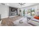 Living room featuring a fireplace, a gray sectional, and a large sliding door to the patio at 313 E Fourth St, Wendell, NC 27591