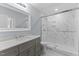Updated bathroom with a gray vanity, marble shower, and a large mirror at 402 Sparella St, Durham, NC 27703