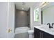 Modern bathroom with gray tile, a bathtub, and a floating vanity at 508 Lakeland St # A, Durham, NC 27701
