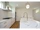 Modern kitchen with white cabinets, quartz countertops, and a gold faucet at 508 Lakeland St # B, Durham, NC 27701