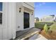 A close-up view of a home's black front door with elegant lighting, surrounded by well-maintained landscaping at 51 Pansy Park # 234, Clayton, NC 27520
