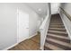 Bright hallway featuring wood-look flooring, white doors, and a carpeted staircase, creating a welcoming entry at 51 Pansy Park # 234, Clayton, NC 27520