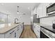 Open kitchen area with a large island, modern appliances, sleek white cabinets, and hardwood floors, creating a harmonious space at 51 Pansy Park # 234, Clayton, NC 27520