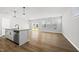 Bright open-concept living area with hardwood floors, large windows, and a kitchen island, creating a modern and inviting space at 51 Pansy Park # 234, Clayton, NC 27520