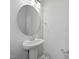 Stylish powder room featuring a pedestal sink, round mirror, and brushed nickel fixtures at 51 Pansy Park # 234, Clayton, NC 27520