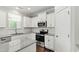 Well-lit kitchen features white cabinets, granite countertops, and stainless steel appliances at 528 Ballast Pt, Clayton, NC 27520