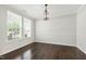 Bright living room with hardwood floors, two windows, and modern light fixture at 528 Ballast Pt, Clayton, NC 27520