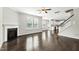 Spacious living room featuring hardwood floors, fireplace, staircase, and kitchen views at 528 Ballast Pt, Clayton, NC 27520