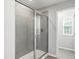 Modern walk-in shower featuring gray tiles and a glass door enclosure at 528 Ballast Pt, Clayton, NC 27520