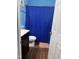 Simple bathroom with a dark vanity, a toilet, and a blue shower curtain for a clean and functional space at 5430 Neuse Ridge Rd, Raleigh, NC 27610