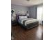 Bedroom with neutral walls, wood floor, a decorative headboard, and soft, comfortable bedding at 5430 Neuse Ridge Rd, Raleigh, NC 27610