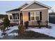 Well-maintained home featuring a classic design, with a front porch and neat landscaping, partially covered in snow at 5430 Neuse Ridge Rd, Raleigh, NC 27610