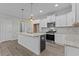 Modern kitchen with white cabinets, granite counters, and stainless steel appliances at 607 Marshskip Way, Rolesville, NC 27571