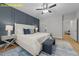 Luxurious main bedroom suite boasts a king bed, accent wall, ceiling fan, and seamless flow to the bathroom at 607 Marshskip Way, Rolesville, NC 27571