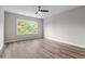 Bright bedroom with large window, ceiling fan, and wood-look floors at 609 Marshskip Way, Rolesville, NC 27571