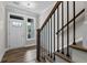 Bright entryway with hardwood floors, white door, and staircase with black railing at 609 Marshskip Way, Rolesville, NC 27571