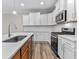 Modern kitchen with white cabinets, stainless steel appliances and quartz countertops at 609 Marshskip Way, Rolesville, NC 27571