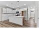 Open kitchen with white cabinets, an island, and hardwood floors at 609 Marshskip Way, Rolesville, NC 27571