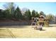 Large backyard with playground set and fire pit at 7713 Stonehenge Farm Ln, Raleigh, NC 27613