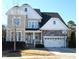 Two-story house with stone accents, a large garage, and a basketball hoop at 7713 Stonehenge Farm Ln, Raleigh, NC 27613