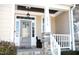 Inviting front porch with stone pillars and gray door at 7713 Stonehenge Farm Ln, Raleigh, NC 27613