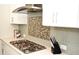 Modern kitchen with white cabinets, gas cooktop and stainless steel appliances at 7713 Stonehenge Farm Ln, Raleigh, NC 27613