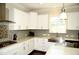 Modern kitchen with white cabinets, a farmhouse sink, and an island at 7713 Stonehenge Farm Ln, Raleigh, NC 27613